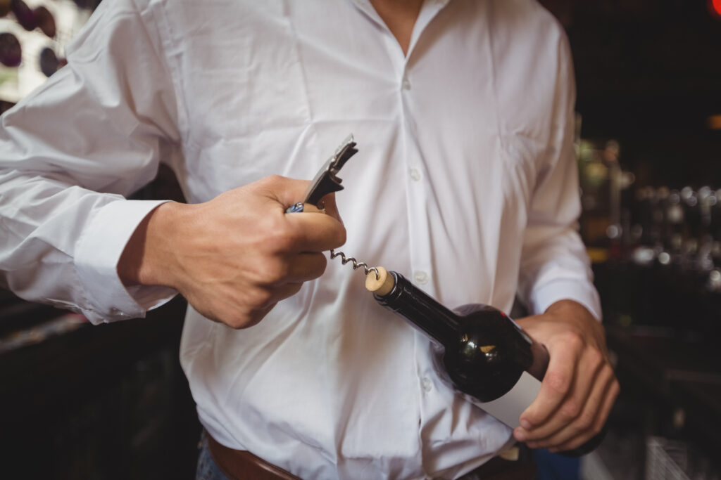 camarero descorchando vino